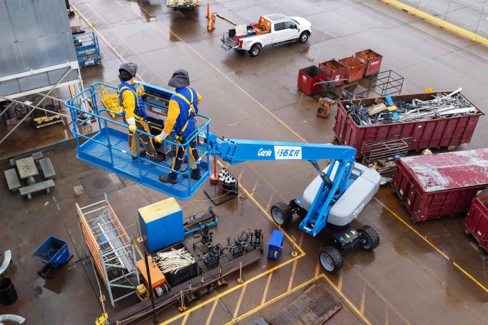 Genie S-85XC FE kjøring med to mann i kurven med bommen hevet